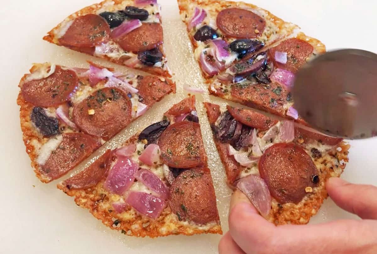 Cutting the pizza into slices on a cutting board.