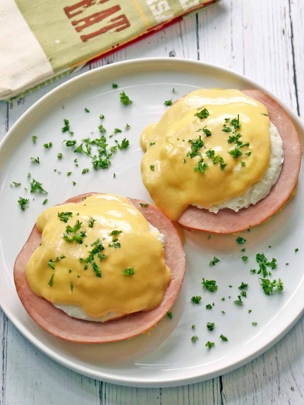 Keto Eggs Benedict is served on a white plate with a napkin.