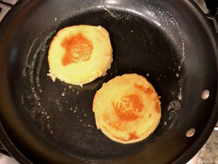 Toasting two pieces of 90-second bread in a skillet.