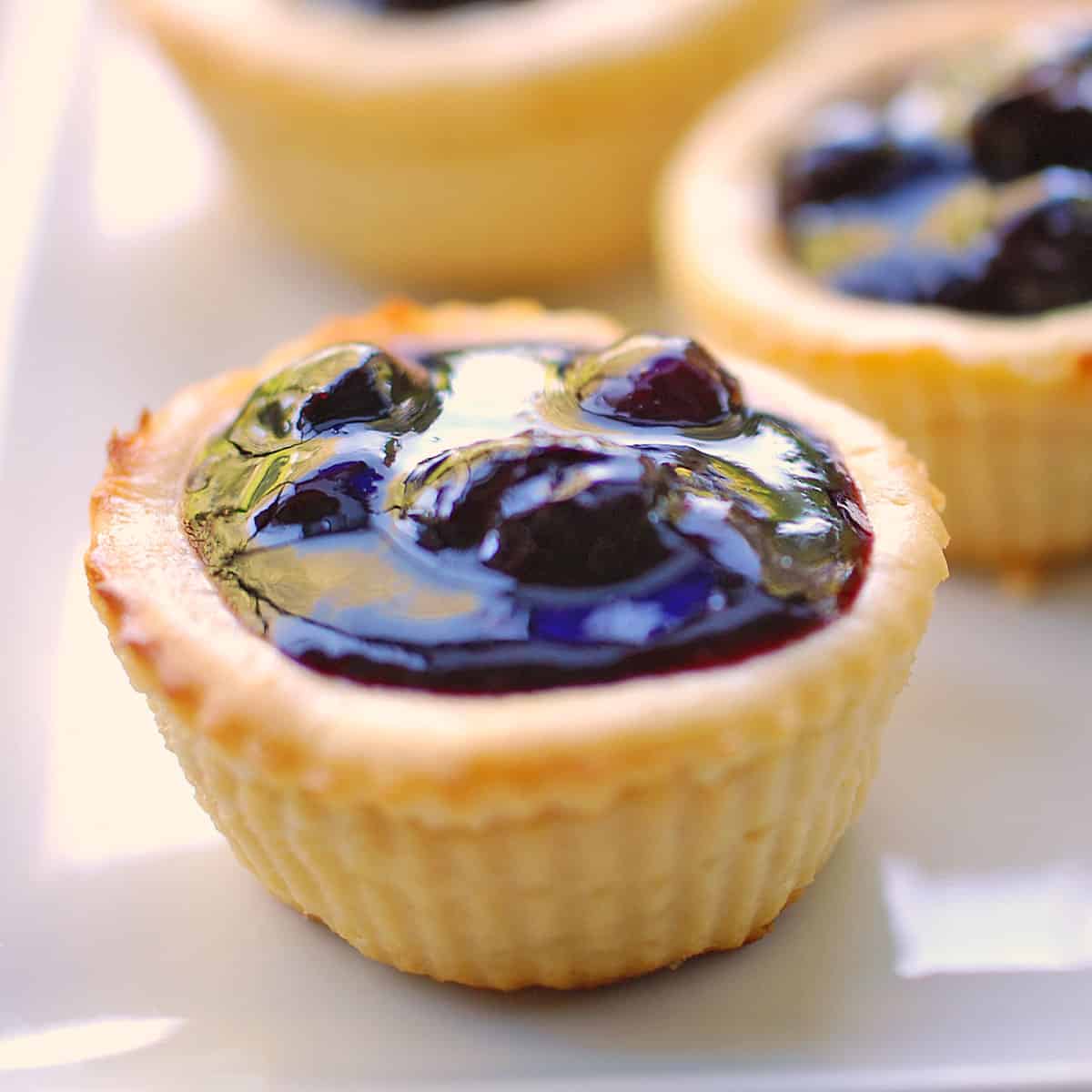 Keto mini cheesecakes are topped with blueberry compote.