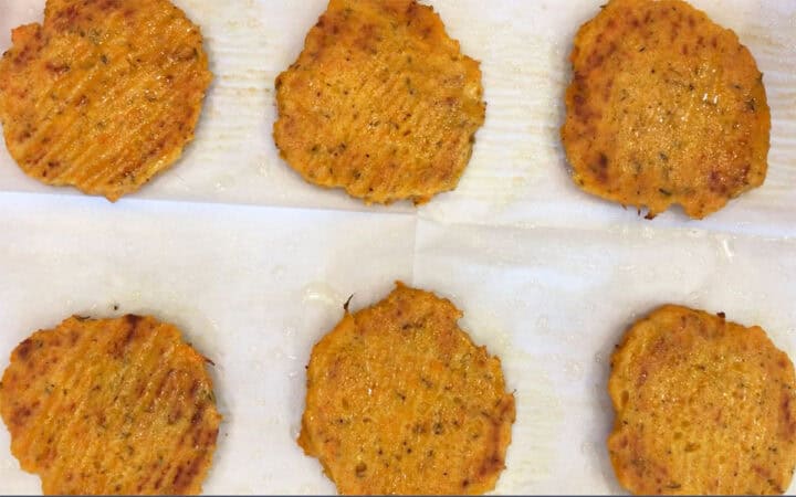 The patties are on the baking sheet after they were flipped.