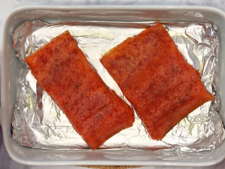 The seasoned salmon pieces were placed in the baking dish.