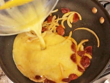 Pouring the eggs into the skillet.