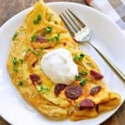 Chorizo omelette is topped with sour cream.