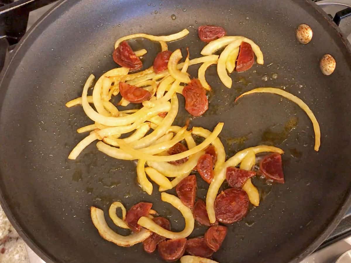 Cooking the onions and chorizo in a skillet.