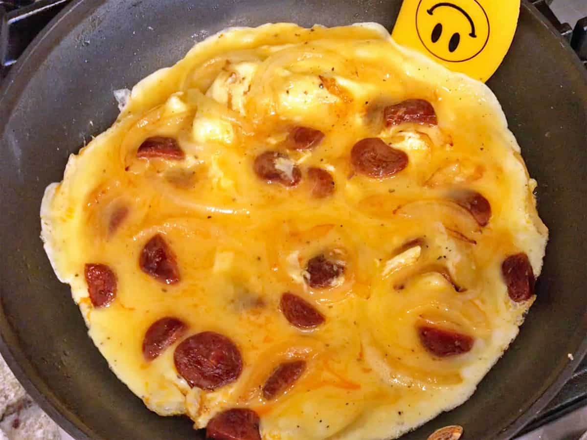 Lifting the omelette edges with a spatula.