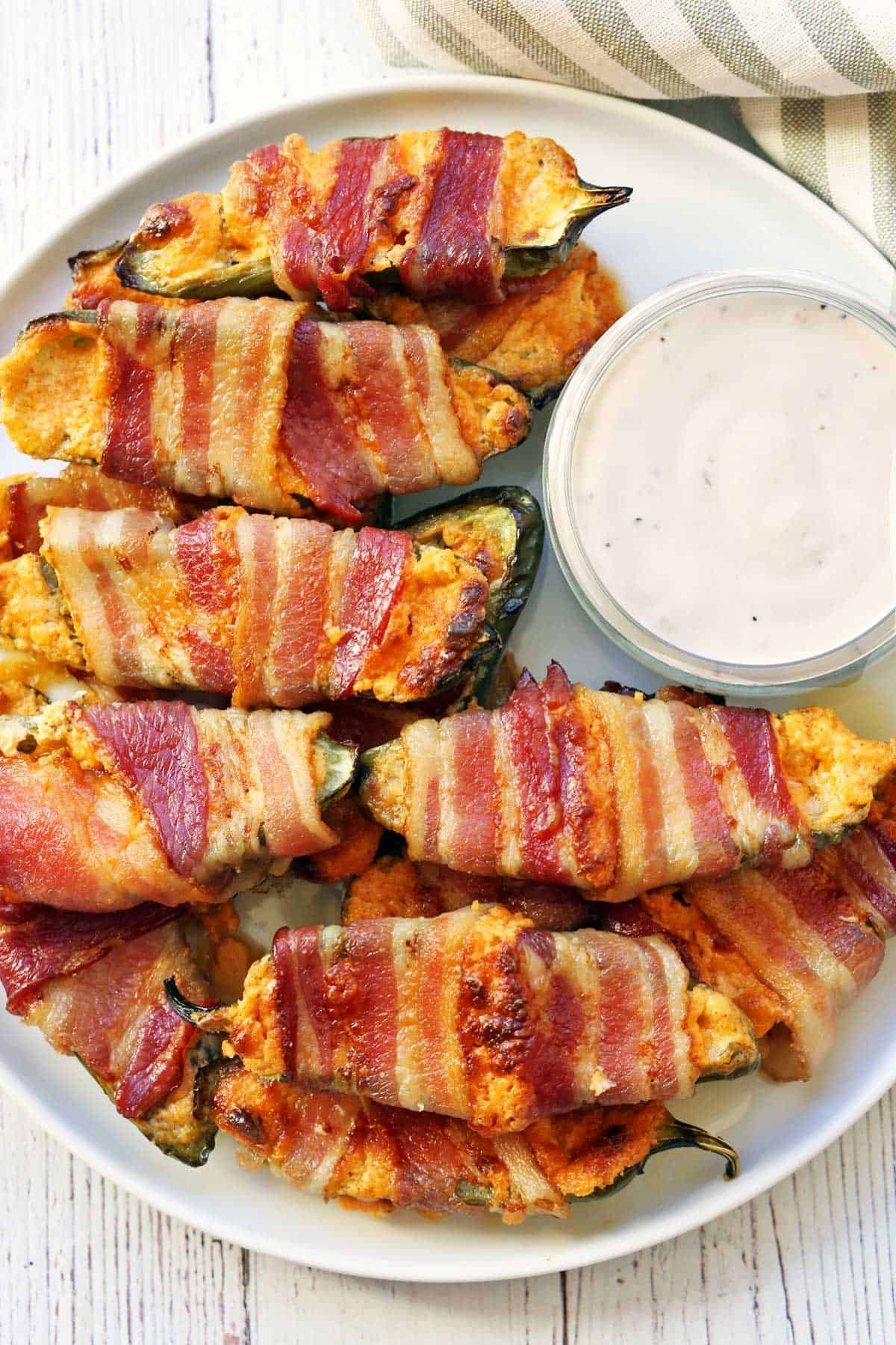 Stuffed jalapenos are served with a dip.