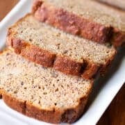 Keto banana bread, sliced, is served on a white tray.